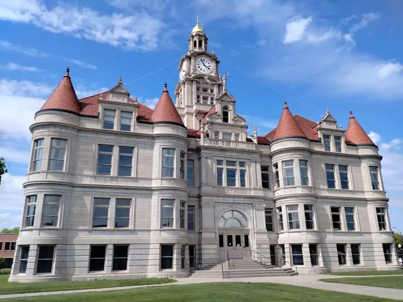 The stone Dallas County Courthouse in Adel with red roofed turrets and a clock tower