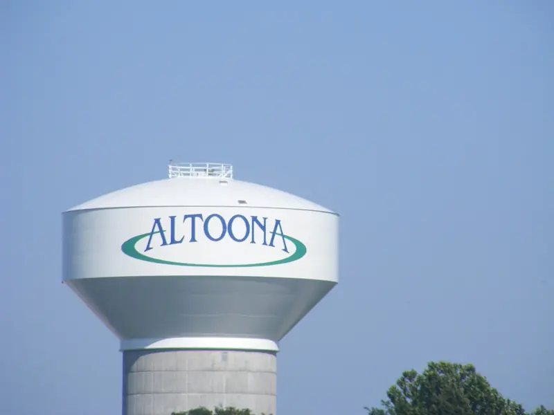 Altoona's white water tower with the city name in blue against a clear sky